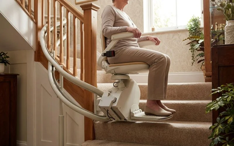 Acorn 180 curved stairlift navigating a 90-degree turn with self-levelling seat
